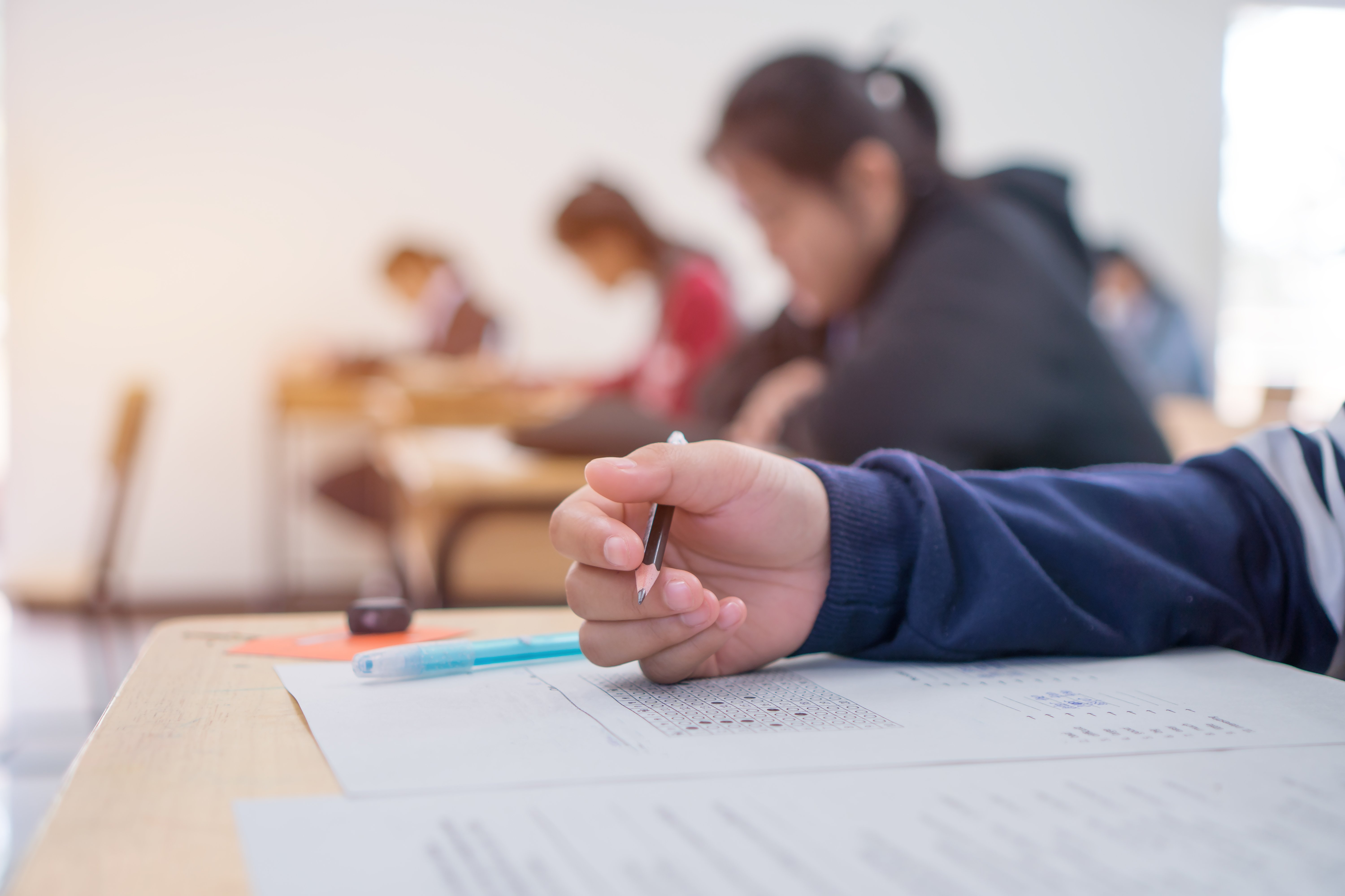 exams-test-student-high-school-university-student-holding-pencil-testing-exam-answer-sheet