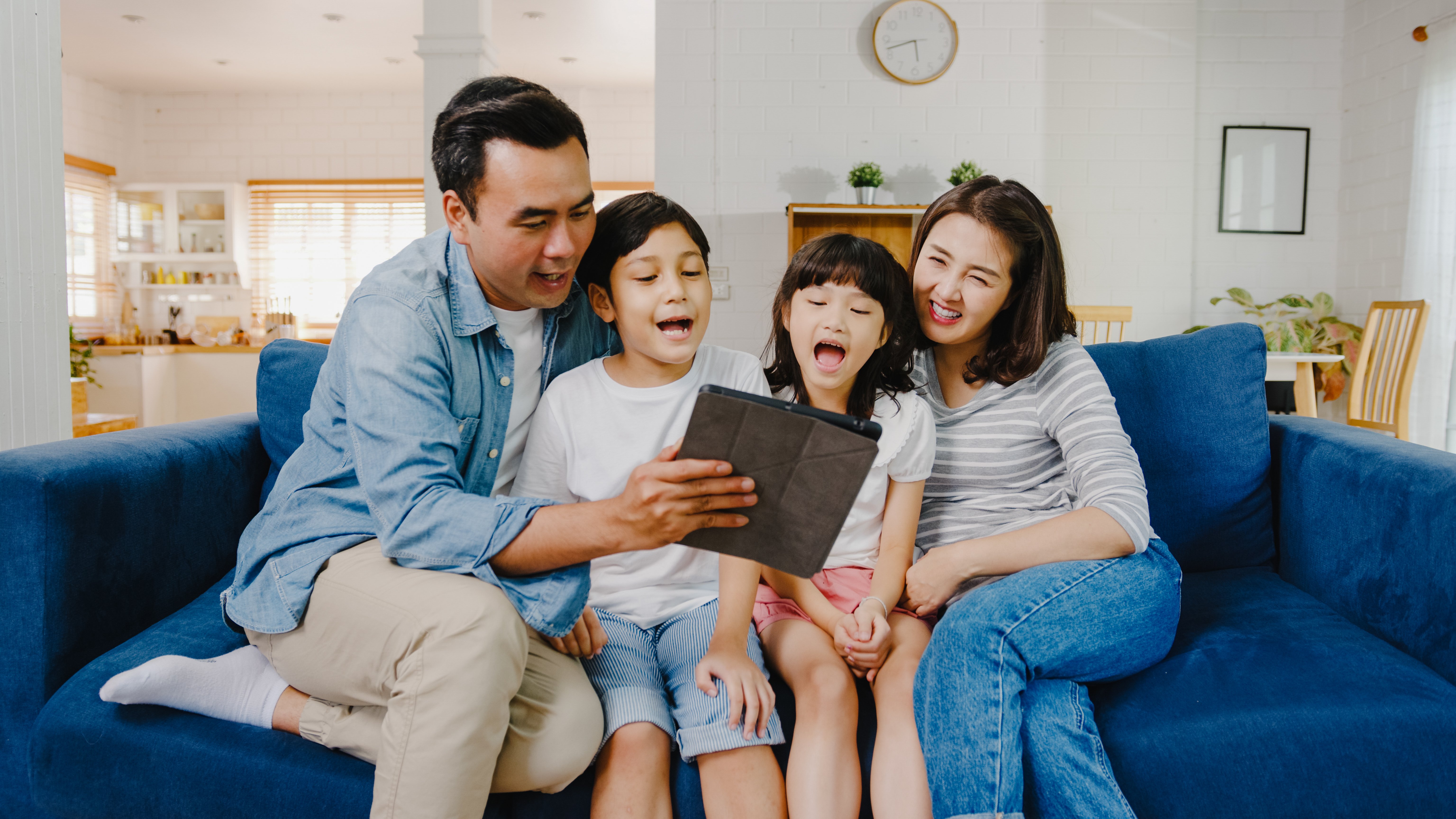 happy-cheerful-asian-family-dad-mom-kids-having-fun-using-digital-tablet-video-call-sofa-house