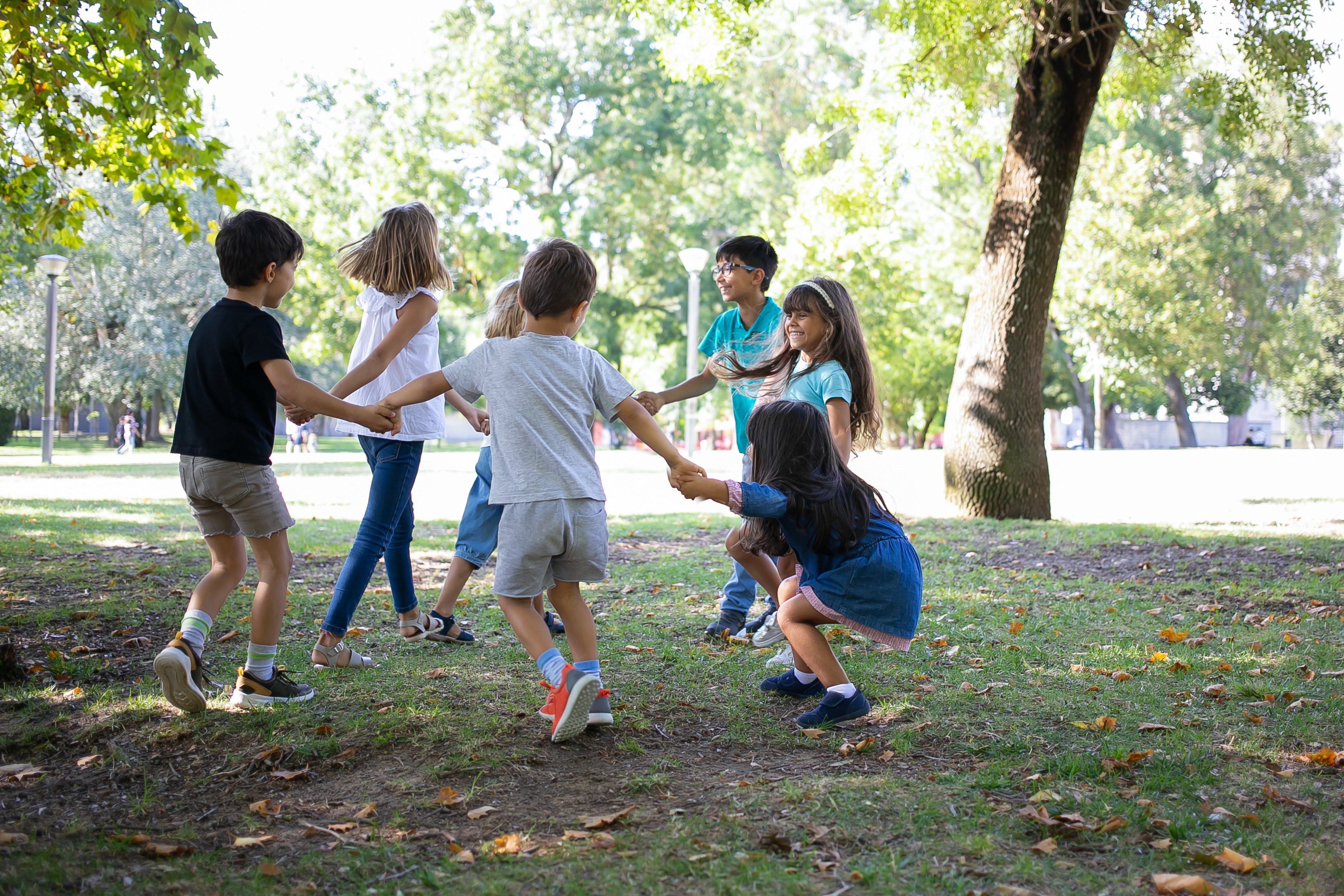 happy-children-playing-together-outdoors-dancing-around-grass-enjoying-outdoor-activities-having-fun-park-kids-party-friendship-concept