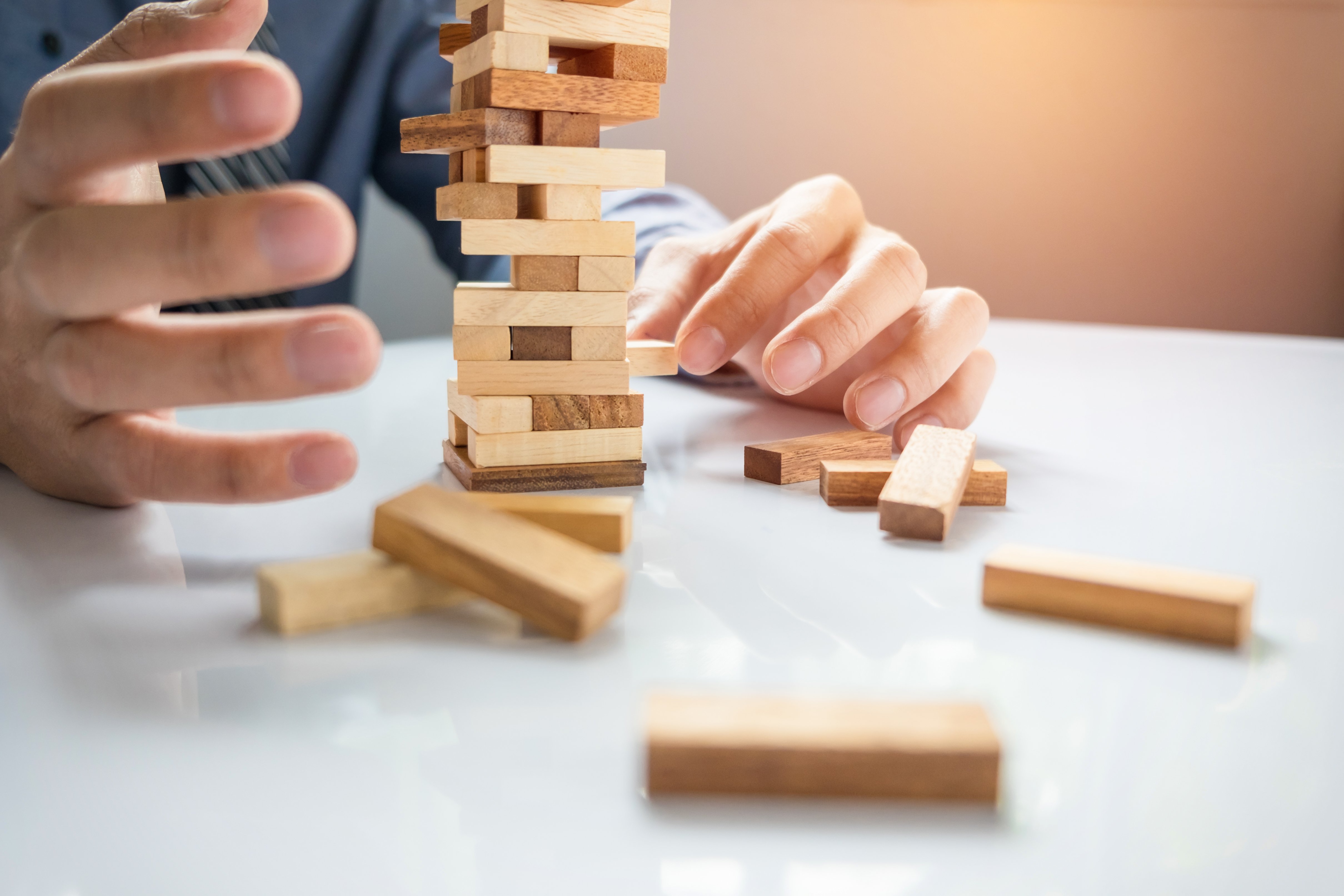 planning-risk-strategy-business-businessman-gambling-placing-wooden-block-tower